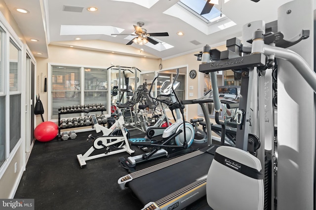 exercise room featuring vaulted ceiling with skylight, ornamental molding, and ceiling fan