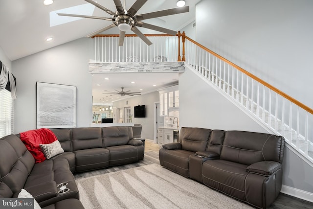 living room with ornamental molding, hardwood / wood-style flooring, plenty of natural light, and a skylight