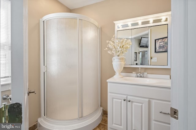 bathroom featuring tile patterned flooring, walk in shower, and vanity