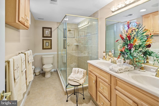 bathroom with an enclosed shower, vanity, tile patterned flooring, and toilet