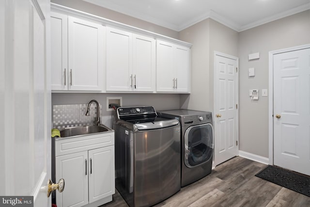 washroom with independent washer and dryer, sink, dark hardwood / wood-style flooring, crown molding, and cabinets