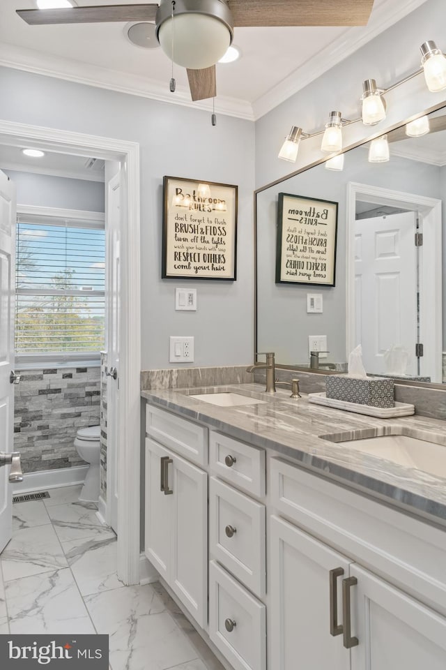 bathroom with ceiling fan, crown molding, vanity, and toilet