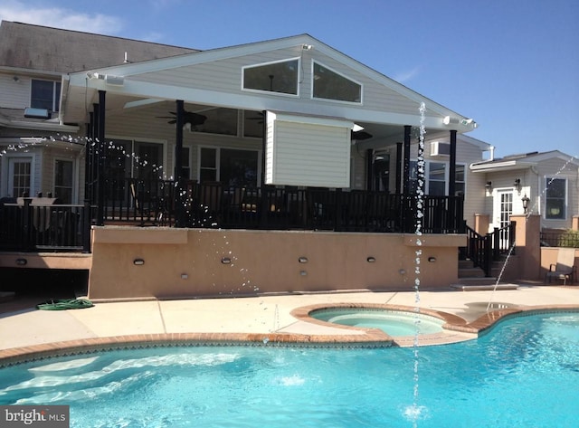 view of swimming pool with an in ground hot tub, pool water feature, a patio area, and ceiling fan