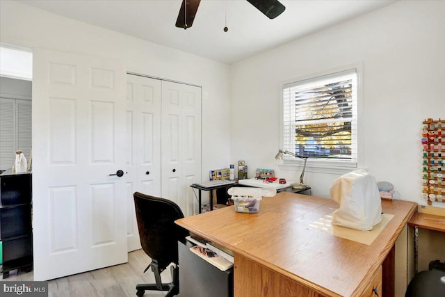 home office with light wood-type flooring and ceiling fan