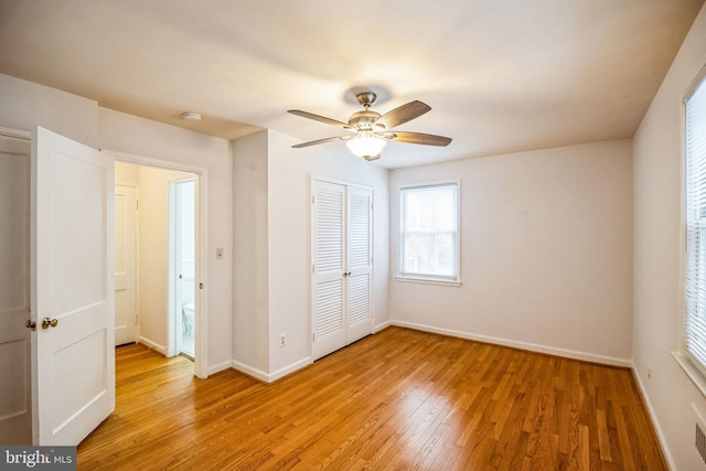 unfurnished bedroom featuring light hardwood / wood-style floors, a closet, and ceiling fan