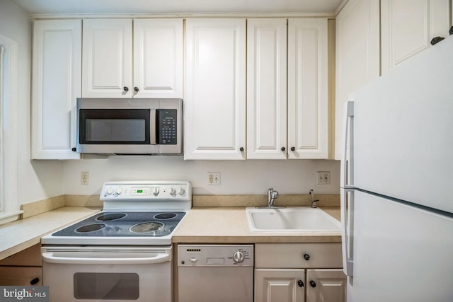 kitchen featuring white cabinetry, sink, and white appliances