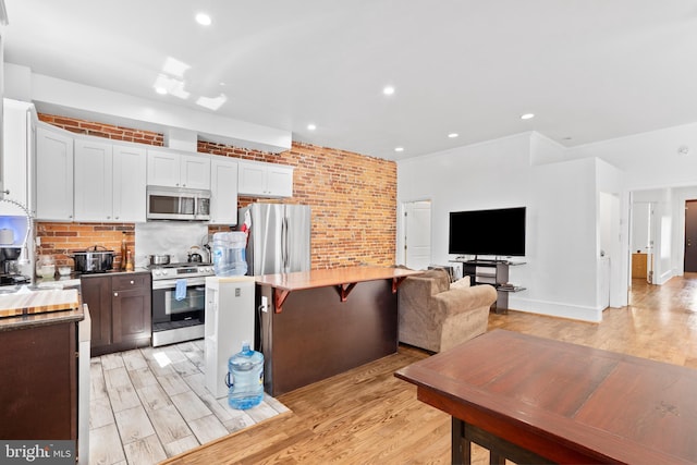 4830 Cedar Ave, Philadelphia, PA 19143 - kitchen featuring stainless steel appliances, tasteful backsplash, and light wood finished floors