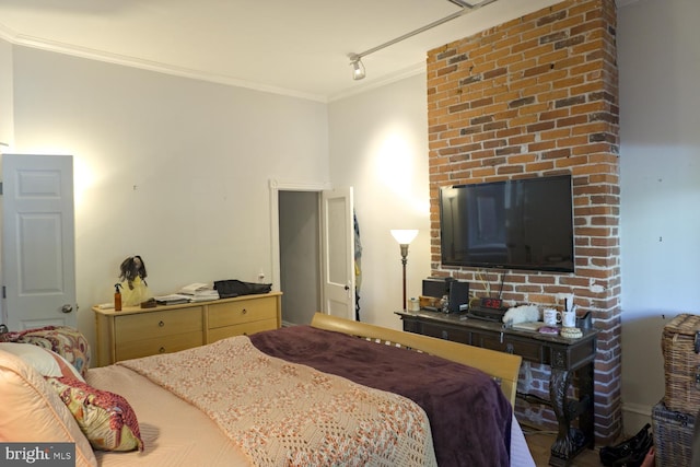 bedroom featuring ornamental molding and track lighting