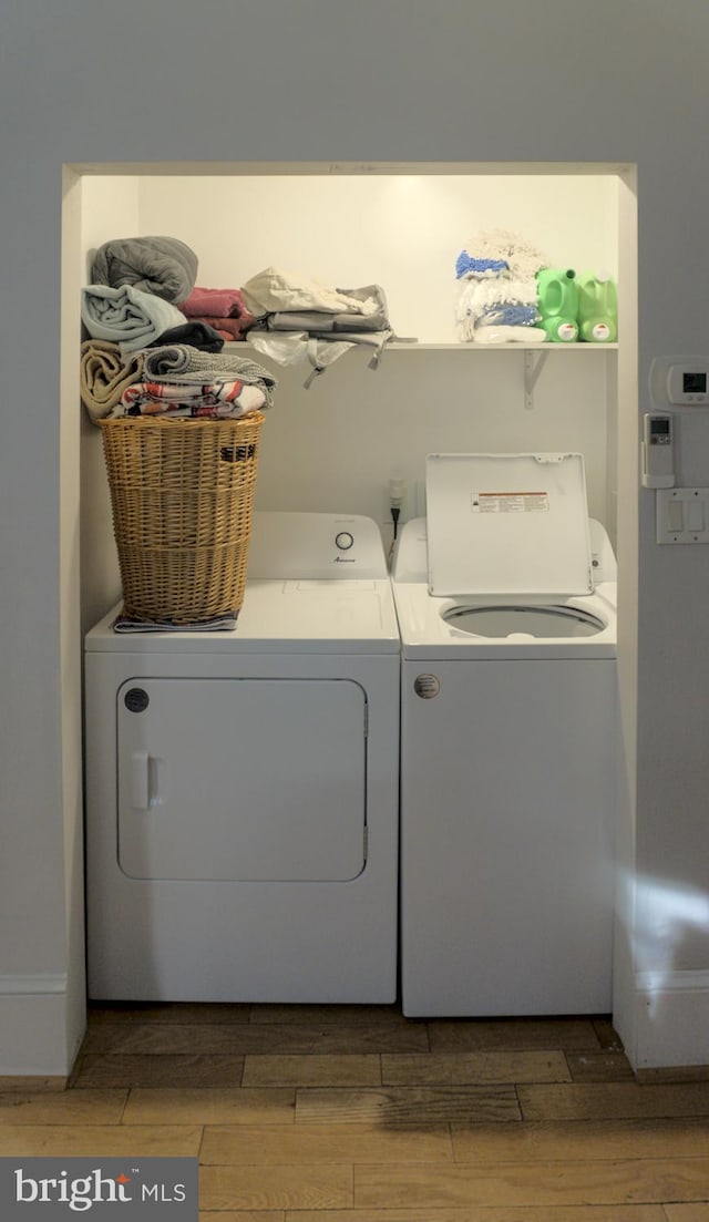 laundry area featuring washing machine and dryer and light hardwood / wood-style floors