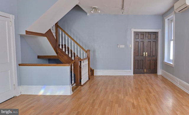 foyer with light hardwood / wood-style floors and a wall mounted AC