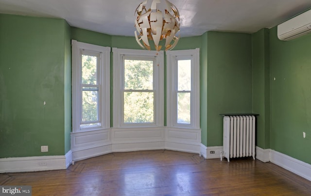 empty room with dark wood-type flooring, a healthy amount of sunlight, radiator, and a wall mounted air conditioner