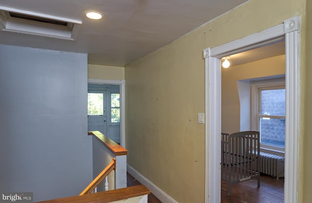 hall featuring dark wood-type flooring and radiator heating unit