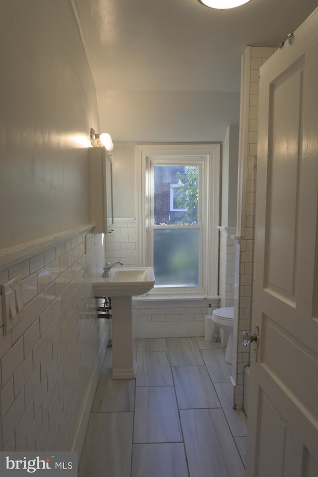 bathroom featuring tile walls, toilet, and tile patterned floors