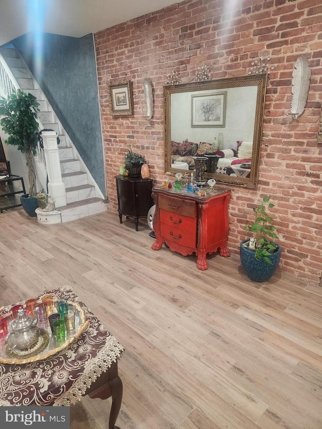 interior space with light hardwood / wood-style floors and brick wall