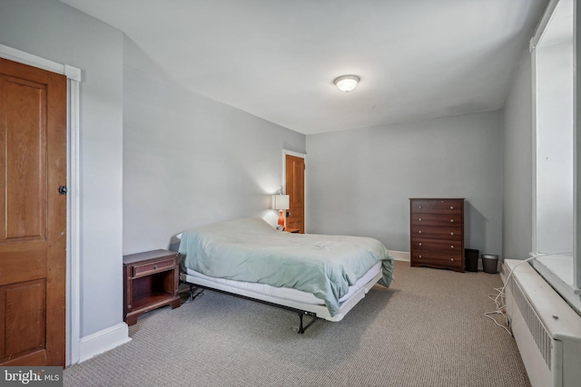 bedroom with light carpet and radiator heating unit