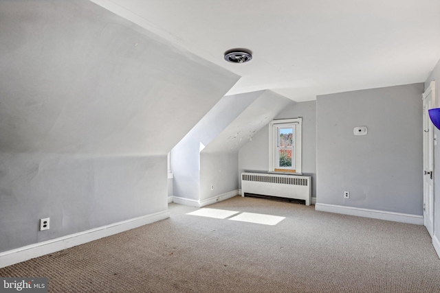 bonus room featuring vaulted ceiling, light carpet, and radiator