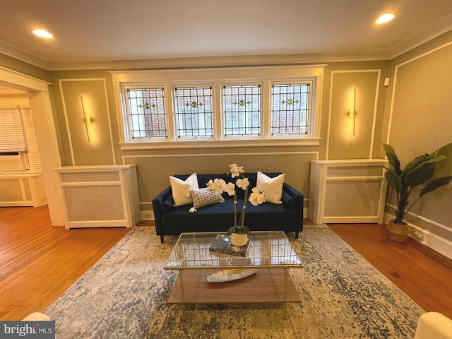 living room featuring ornamental molding and wood-type flooring