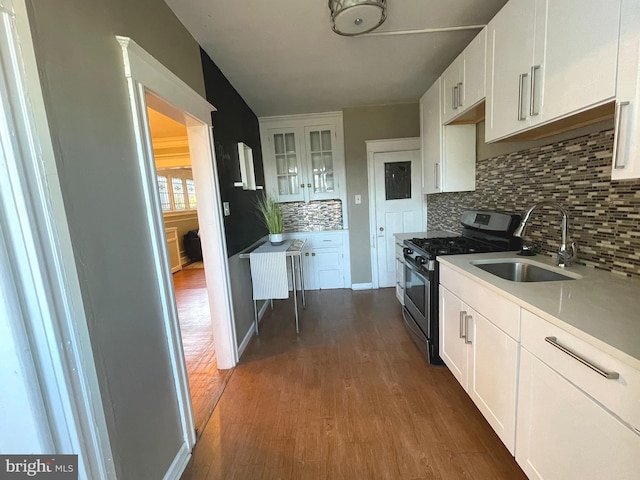 kitchen with dark hardwood / wood-style flooring, white cabinets, sink, and stainless steel range with gas stovetop