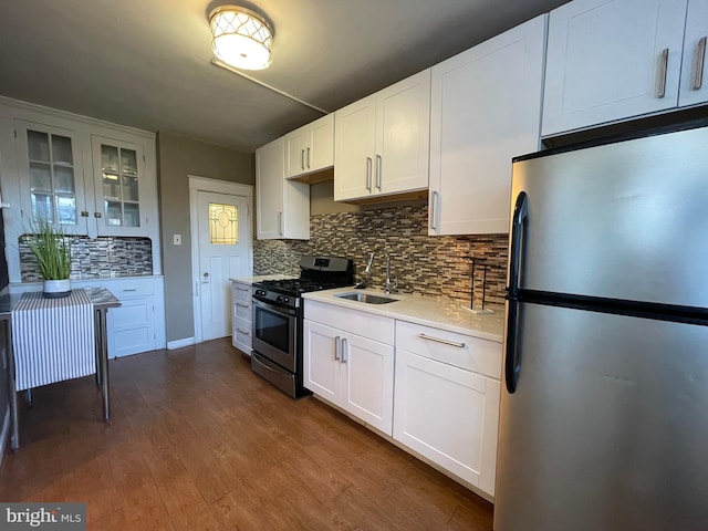 kitchen with decorative backsplash, dark wood-type flooring, sink, white cabinets, and appliances with stainless steel finishes