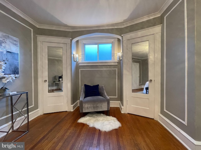 sitting room with ornamental molding and dark hardwood / wood-style flooring