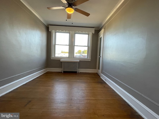 empty room with dark wood-type flooring, crown molding, radiator heating unit, and ceiling fan