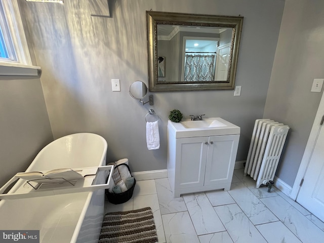 bathroom with a washtub, vanity, and radiator