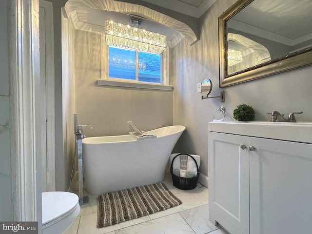 bathroom featuring vanity, crown molding, toilet, and a bathtub