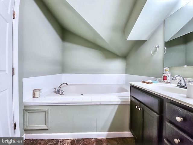 bathroom featuring a washtub, vanity, and vaulted ceiling