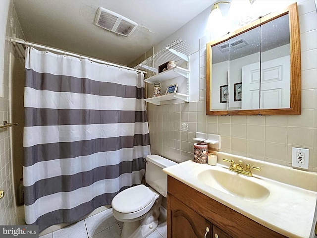 bathroom with tasteful backsplash, tile walls, vanity, tile patterned flooring, and toilet