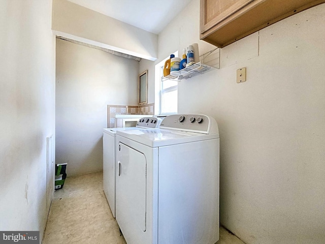 clothes washing area with cabinets and washer and dryer