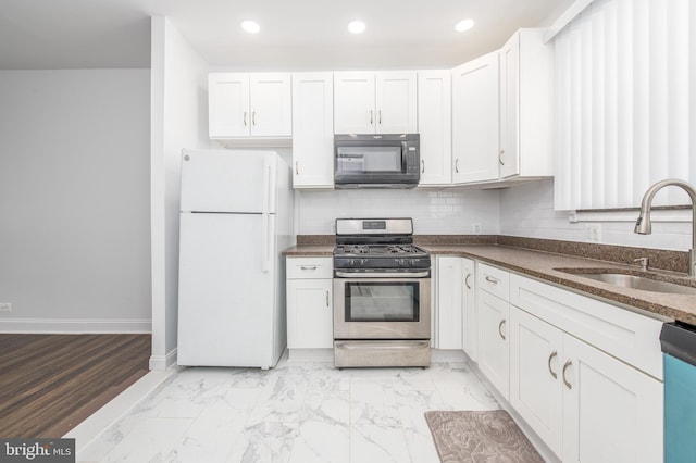 kitchen with white cabinets, appliances with stainless steel finishes, and sink