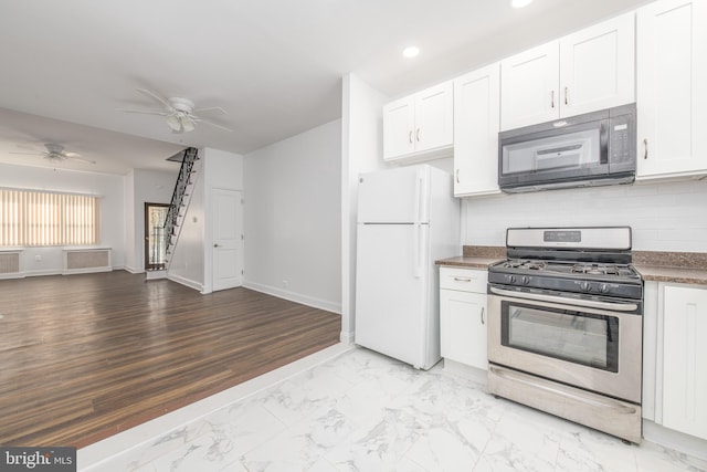 kitchen featuring stainless steel gas range oven, white fridge, white cabinets, and light hardwood / wood-style flooring