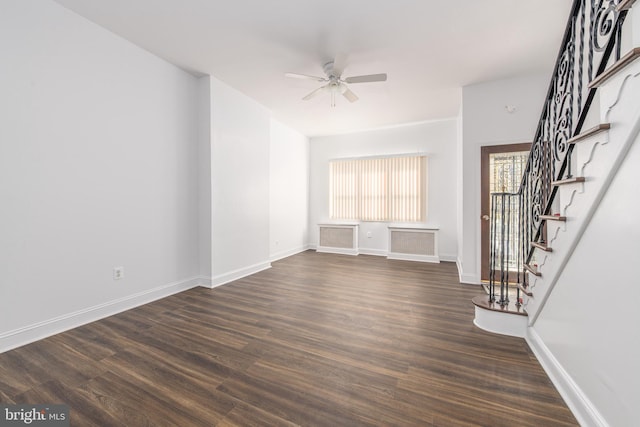 unfurnished living room featuring ceiling fan and dark wood-type flooring