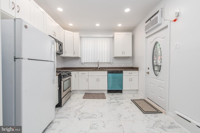 kitchen featuring white cabinets, sink, appliances with stainless steel finishes, a baseboard radiator, and a wall mounted AC