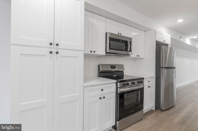 kitchen with white cabinetry, light hardwood / wood-style floors, and appliances with stainless steel finishes