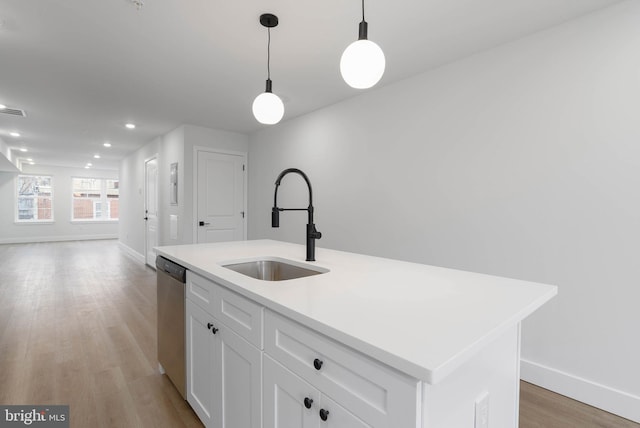 kitchen featuring sink, white cabinetry, hanging light fixtures, stainless steel dishwasher, and a kitchen island with sink