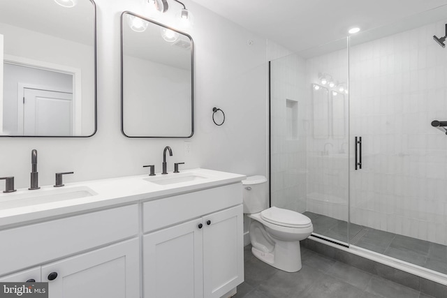 bathroom featuring a shower with door, vanity, and toilet