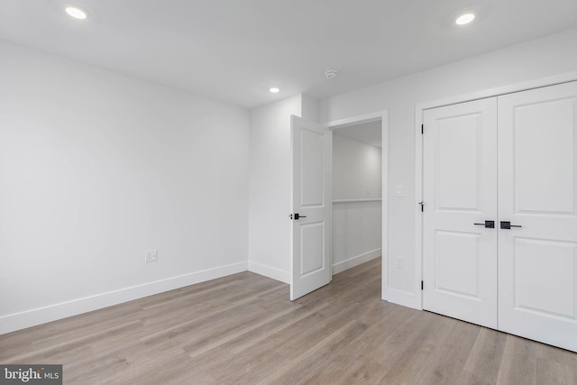 unfurnished bedroom featuring light wood-type flooring and a closet