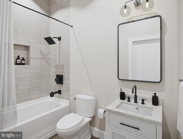 full bathroom featuring shower / tub combo with curtain, vanity, and toilet