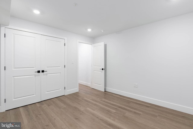 unfurnished bedroom with a closet and light hardwood / wood-style flooring