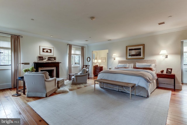 bedroom with crown molding and light hardwood / wood-style flooring