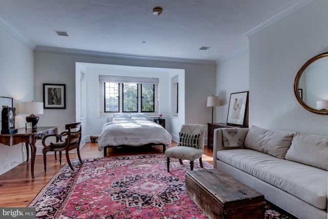 bedroom with ornamental molding and light hardwood / wood-style flooring