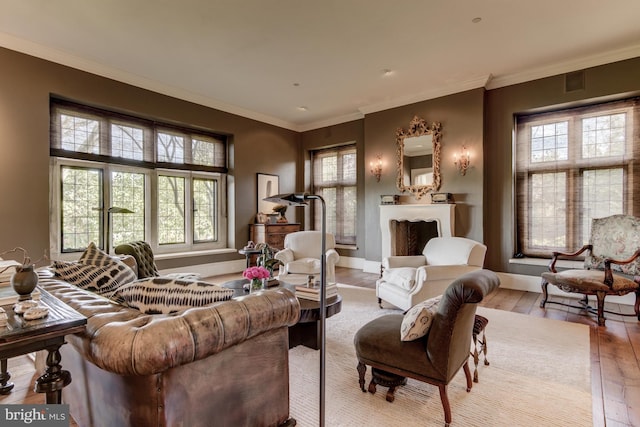 sitting room featuring a wealth of natural light, ornamental molding, and light wood-type flooring