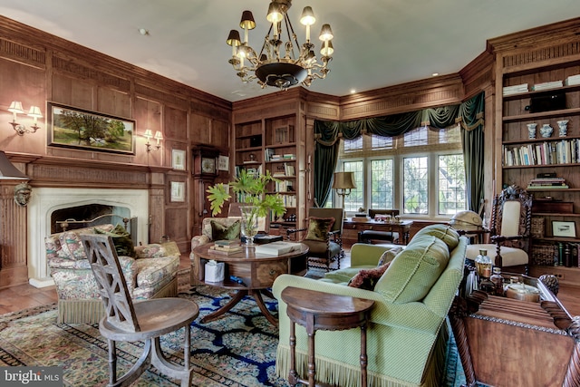 living area featuring built in shelves, wood walls, and a chandelier