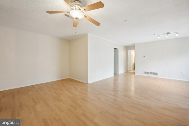 empty room featuring a textured ceiling, light hardwood / wood-style flooring, and ceiling fan