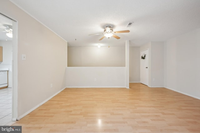 spare room featuring a textured ceiling and light hardwood / wood-style floors