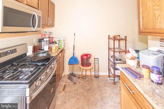 kitchen with light stone countertops and stainless steel appliances