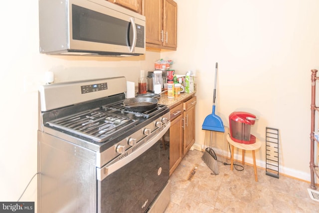 kitchen with light stone countertops and stainless steel appliances