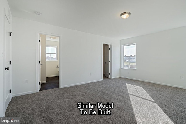 unfurnished bedroom with ensuite bath and dark carpet