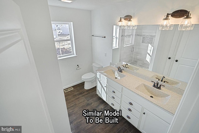 bathroom featuring toilet, wood-type flooring, vanity, and a shower with shower door